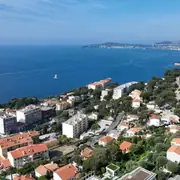 Вид на Средиземное море и побережье с крутыми склонами и окружающей застройкой.